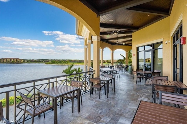 view of patio featuring outdoor dining area, a water view, and ceiling fan