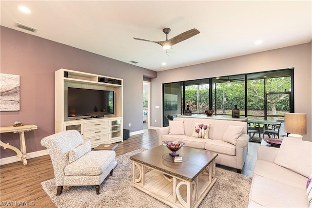 living room with light hardwood / wood-style floors and ceiling fan