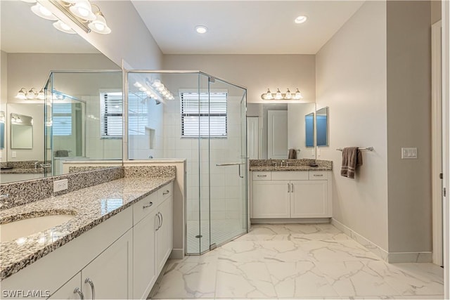 bathroom featuring a shower with door and vanity