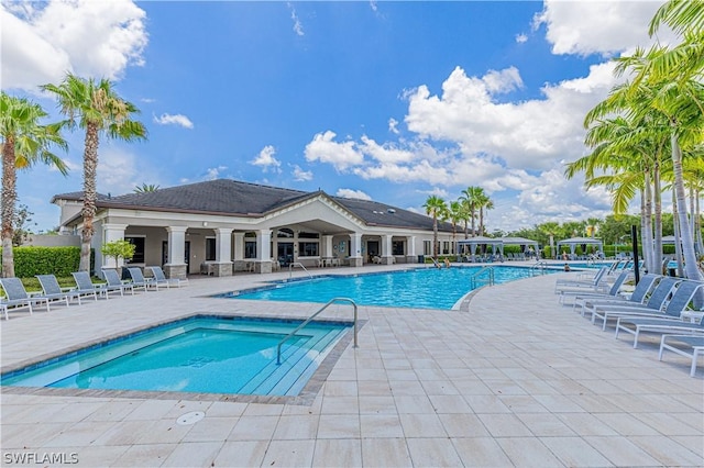 view of swimming pool featuring a patio area and a hot tub