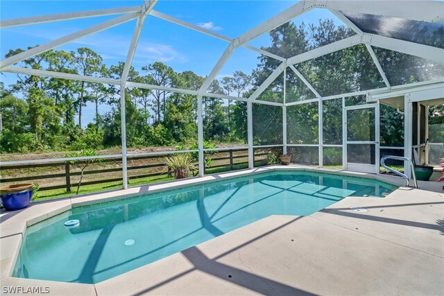 view of swimming pool with a patio area and glass enclosure