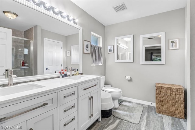 bathroom with vanity, an enclosed shower, and toilet