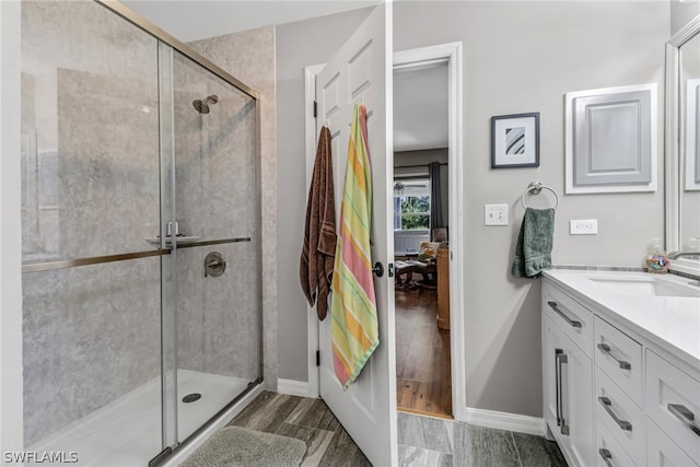 bathroom featuring a shower with door, vanity, and wood-type flooring