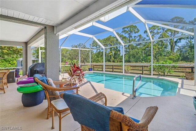 view of swimming pool featuring a lanai and a patio area