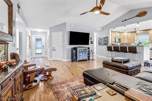 living room featuring ceiling fan, lofted ceiling, and light hardwood / wood-style floors