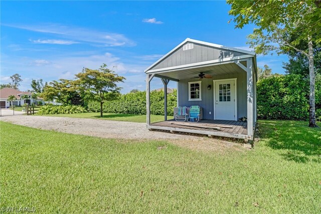 view of front of property with ceiling fan and a front lawn