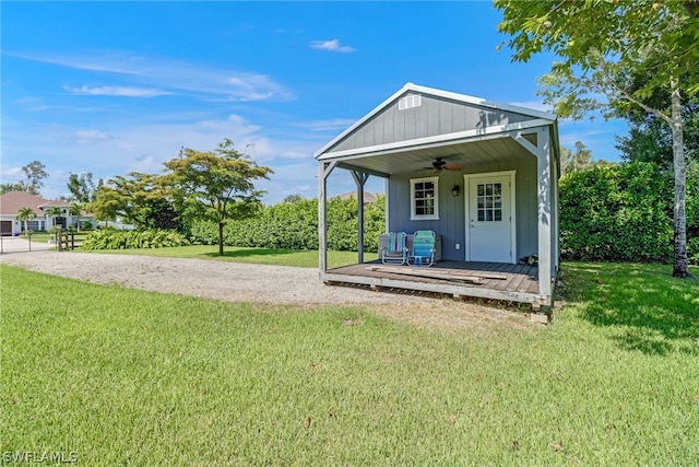 back of house featuring a yard, covered porch, and ceiling fan