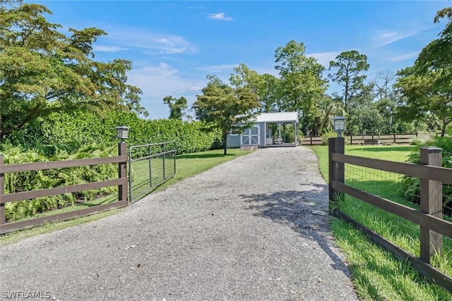 view of gate with a yard