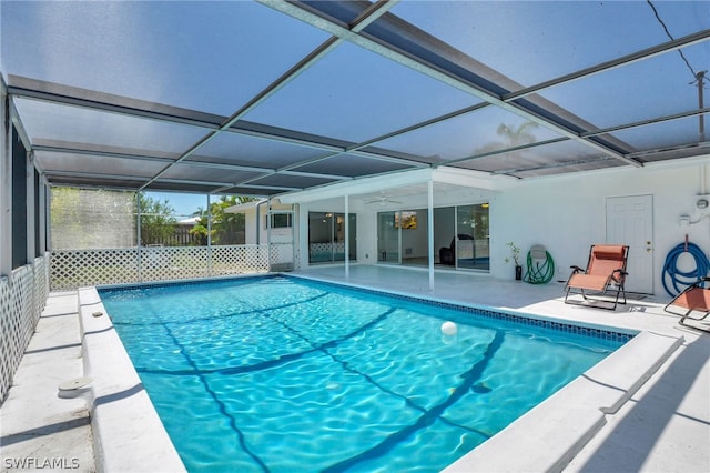 view of swimming pool featuring a lanai, a patio area, and ceiling fan