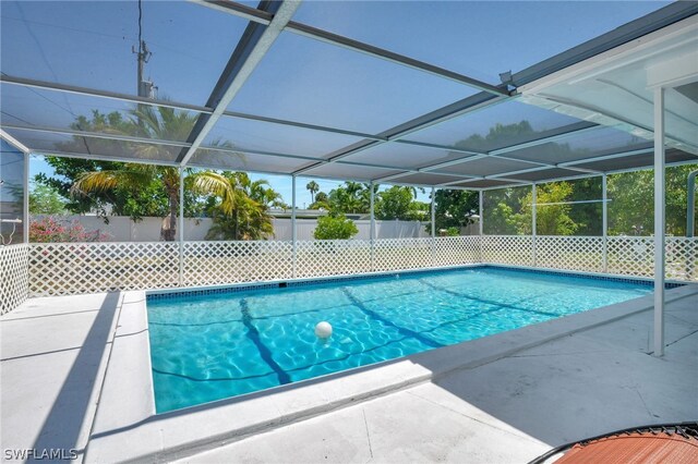 view of pool featuring glass enclosure and a patio area