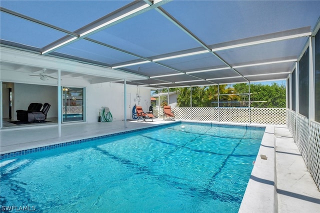 view of swimming pool with ceiling fan, a lanai, and a patio