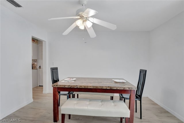 dining space with light hardwood / wood-style floors and ceiling fan