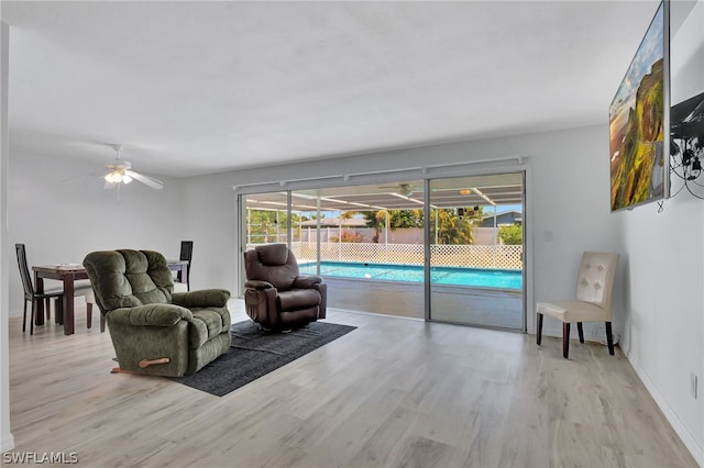 living room featuring light wood-type flooring and ceiling fan