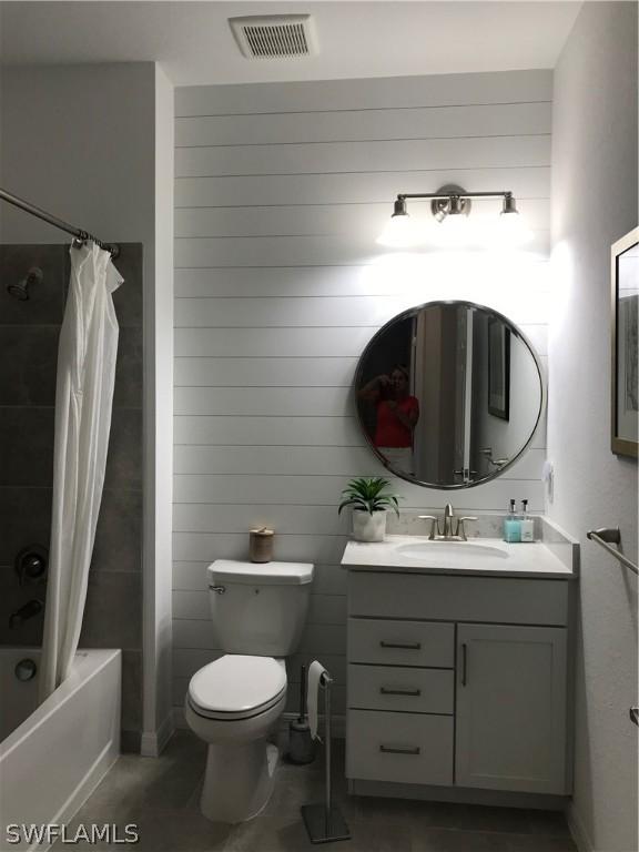 full bathroom with vanity, shower / bathtub combination with curtain, and toilet