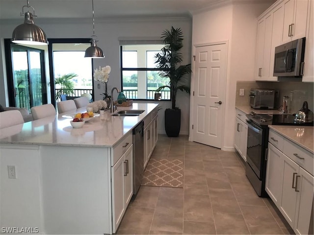 kitchen featuring white cabinetry, sink, light stone countertops, stainless steel appliances, and a kitchen island with sink