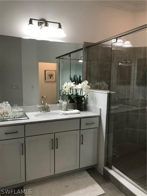 bathroom featuring tile patterned flooring, vanity, walk in shower, and crown molding