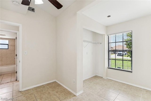 tiled spare room with ceiling fan and plenty of natural light