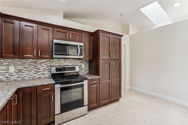 kitchen featuring backsplash, lofted ceiling with skylight, light stone countertops, appliances with stainless steel finishes, and dark brown cabinets