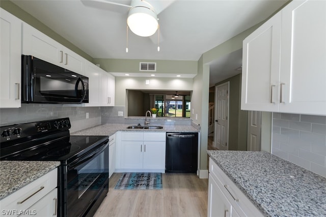 kitchen featuring white cabinetry, sink, tasteful backsplash, light stone counters, and black appliances