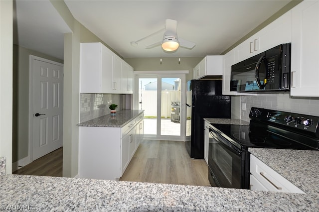 kitchen featuring white cabinets, light wood-style flooring, black appliances, and light stone countertops