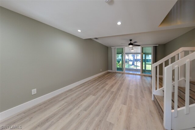 unfurnished living room featuring floor to ceiling windows, ceiling fan, and light wood-type flooring