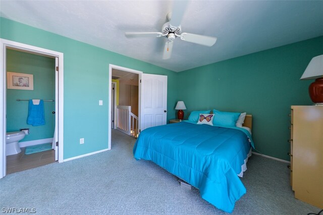 carpeted bedroom with ceiling fan and ensuite bath