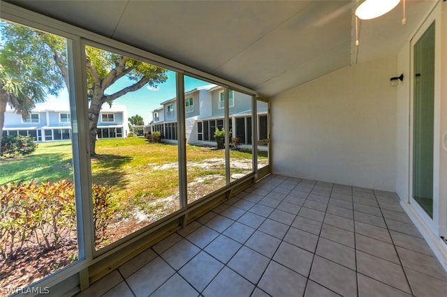 unfurnished sunroom with a residential view and a healthy amount of sunlight