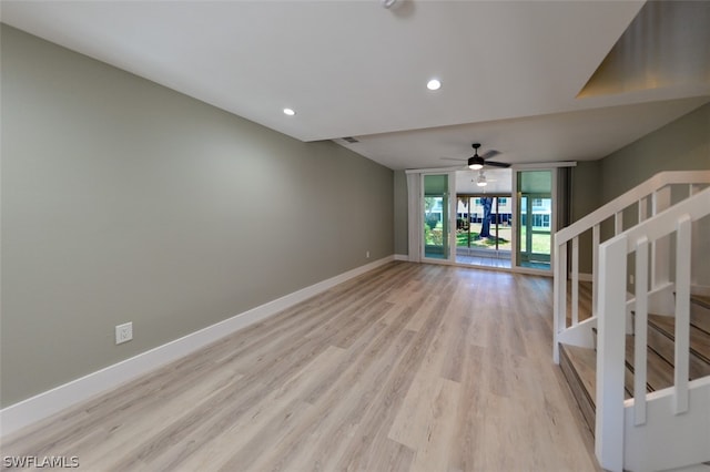 unfurnished living room featuring floor to ceiling windows, ceiling fan, and light wood-type flooring