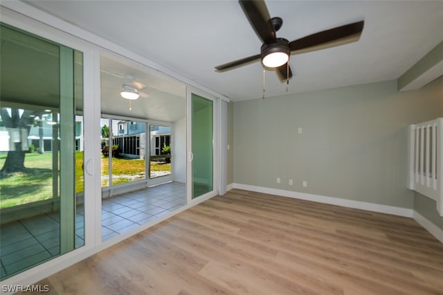 spare room with ceiling fan, wood finished floors, and baseboards