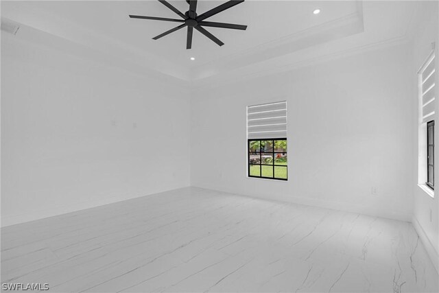 unfurnished room featuring ceiling fan, a raised ceiling, and crown molding