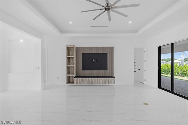 unfurnished living room with ceiling fan and a raised ceiling