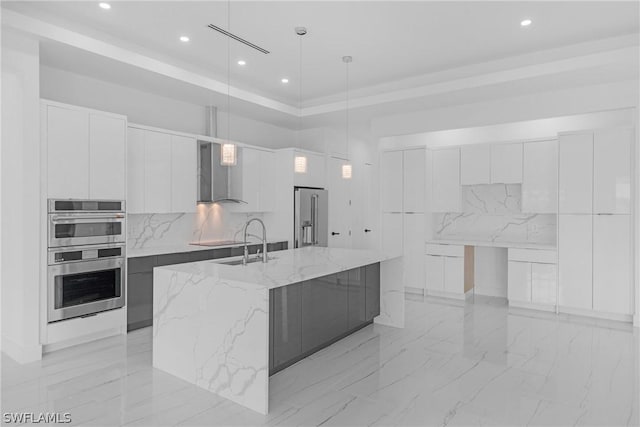 kitchen featuring pendant lighting, white cabinetry, an island with sink, and appliances with stainless steel finishes