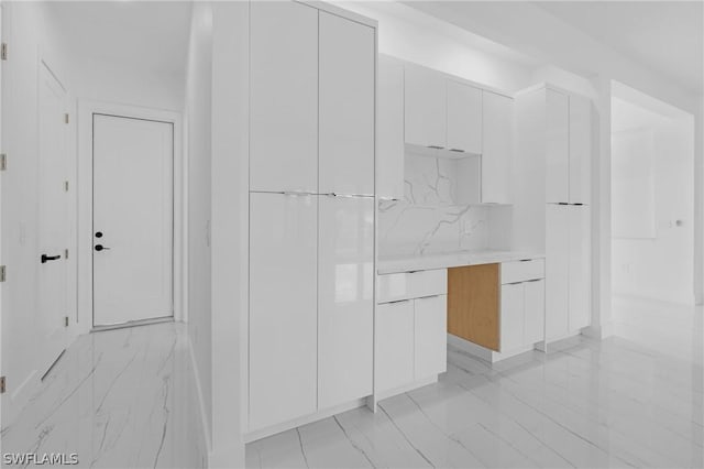 kitchen featuring backsplash and white cabinets