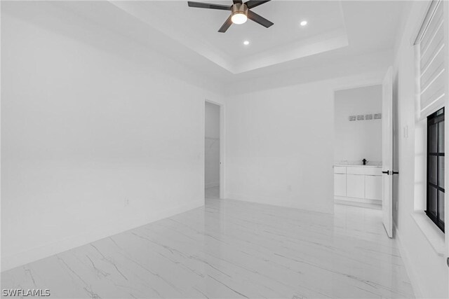 unfurnished room featuring ceiling fan and a tray ceiling