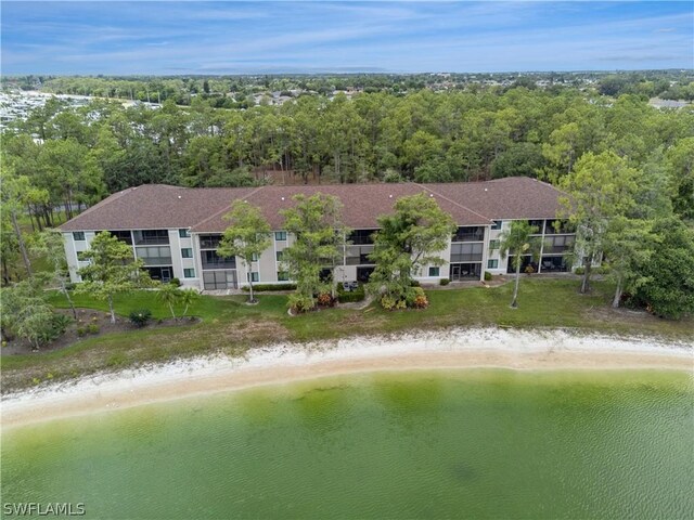 birds eye view of property with a water view and a beach view