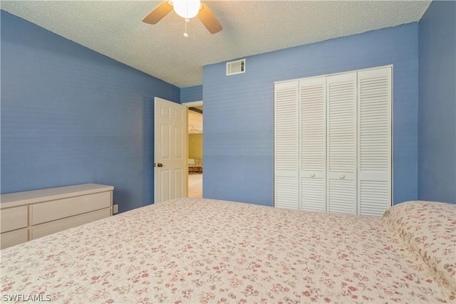 unfurnished bedroom with a ceiling fan, visible vents, a closet, and a textured ceiling