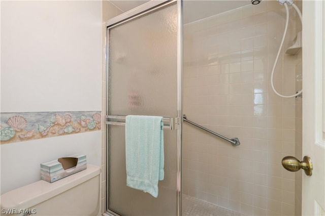 bathroom with toilet and an enclosed shower