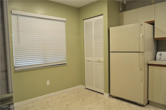 kitchen with baseboards and freestanding refrigerator