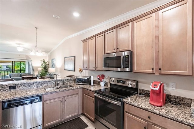 kitchen with sink, decorative light fixtures, vaulted ceiling, appliances with stainless steel finishes, and ornamental molding