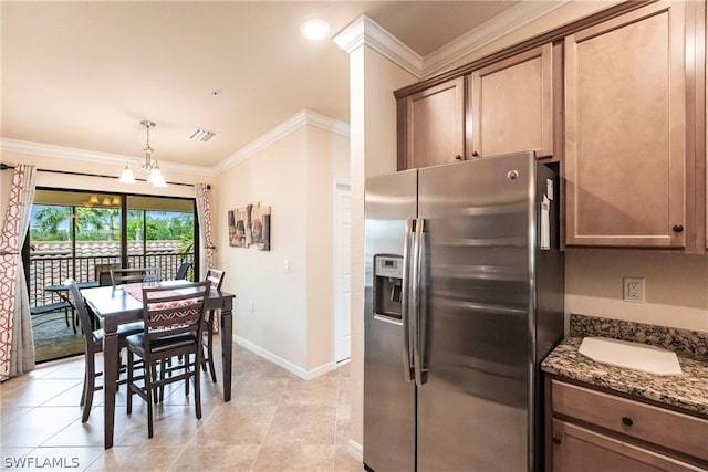 kitchen featuring stainless steel fridge with ice dispenser, a notable chandelier, crown molding, dark stone counters, and decorative light fixtures