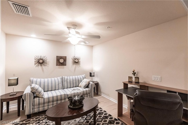 living room featuring ceiling fan and hardwood / wood-style floors