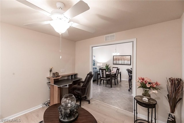 office featuring ceiling fan with notable chandelier