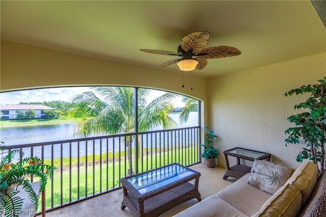 sunroom / solarium featuring ceiling fan and a water view