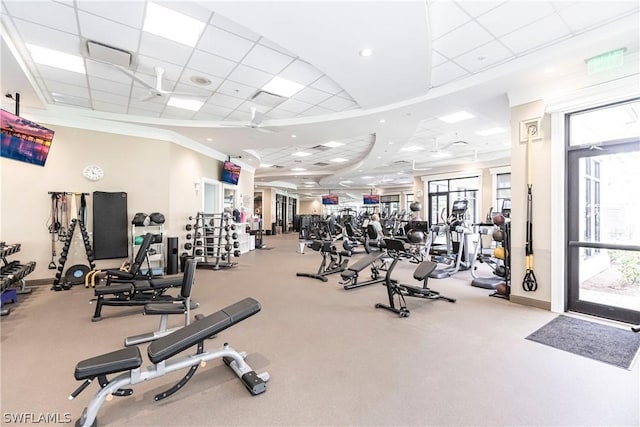 exercise room featuring a paneled ceiling, ceiling fan, and ornamental molding