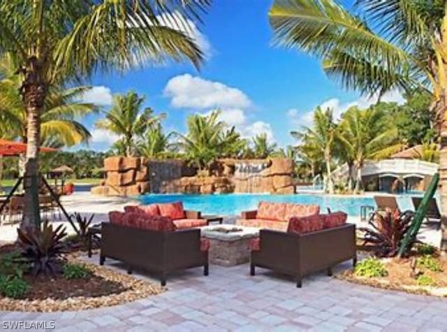 view of patio with an outdoor living space with a fire pit