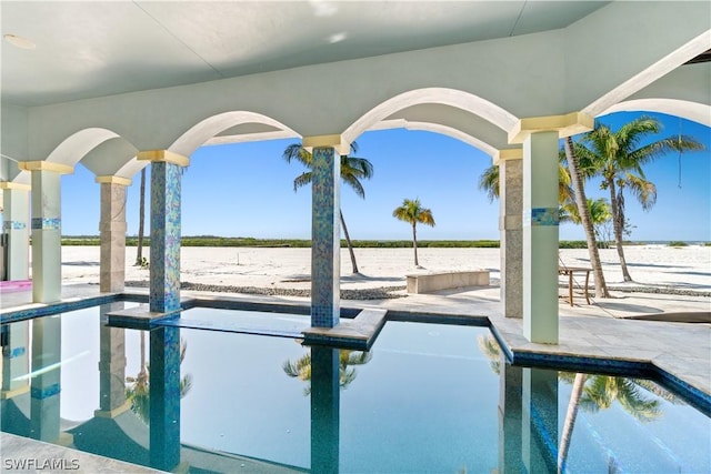 view of swimming pool featuring a water view and a patio area