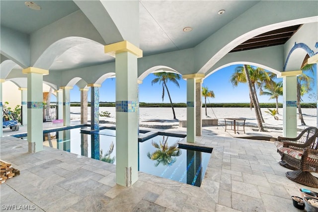 view of pool with a water view and a patio