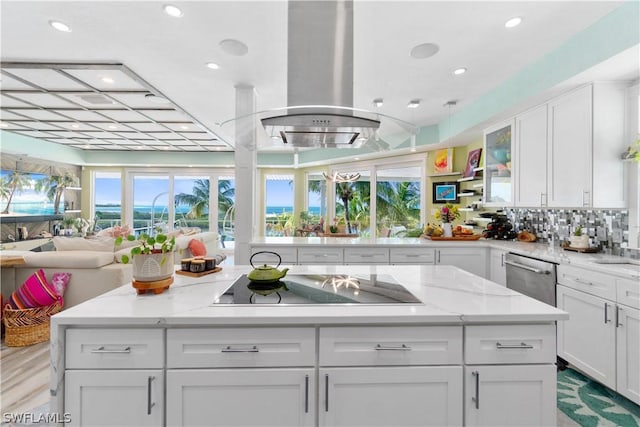 kitchen featuring white cabinetry, light stone counters, island range hood, black electric cooktop, and dishwasher