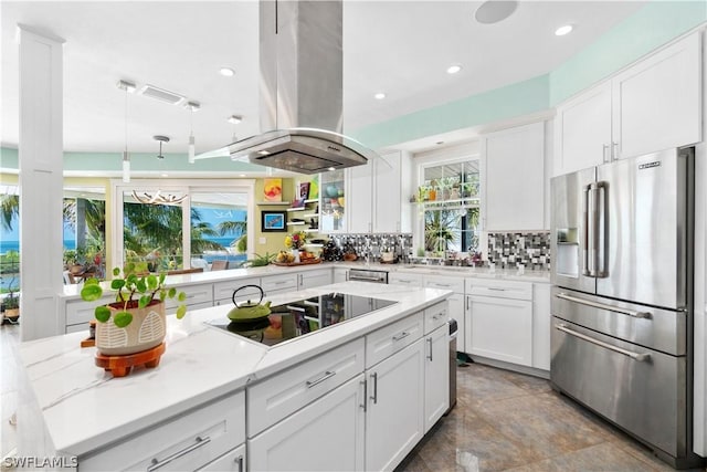 kitchen featuring light stone counters, island range hood, high quality fridge, white cabinets, and black electric cooktop