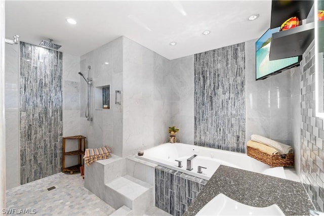 bathroom with tile walls and separate shower and tub